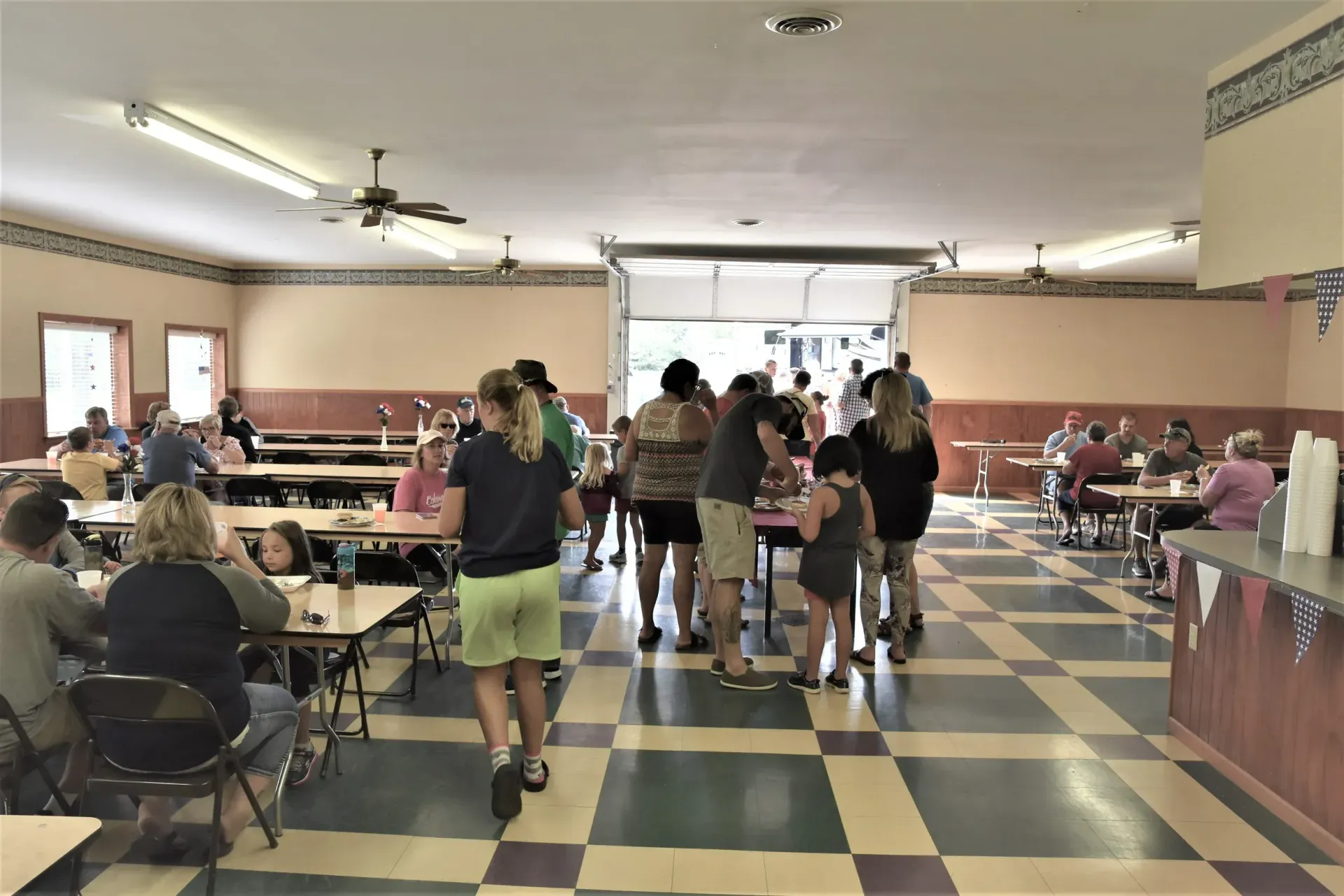 A group of people are sitting at tables in a large room.