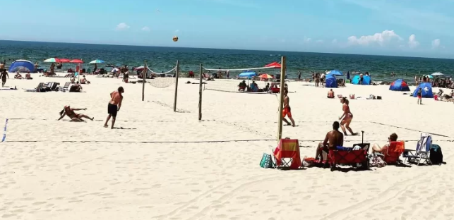 A group of people are playing volleyball on a beach.