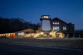 A large stone building with a tower on top of it is lit up at night.