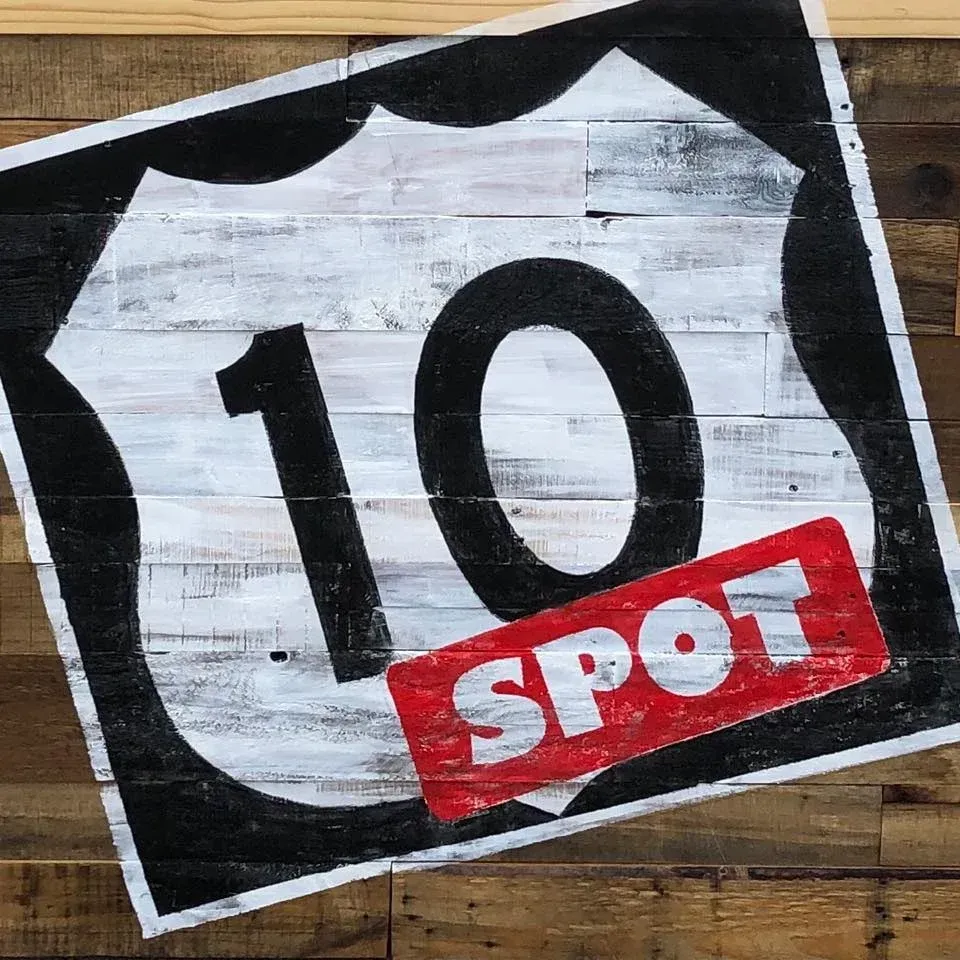 A sign on a wooden wall that says 10 spot