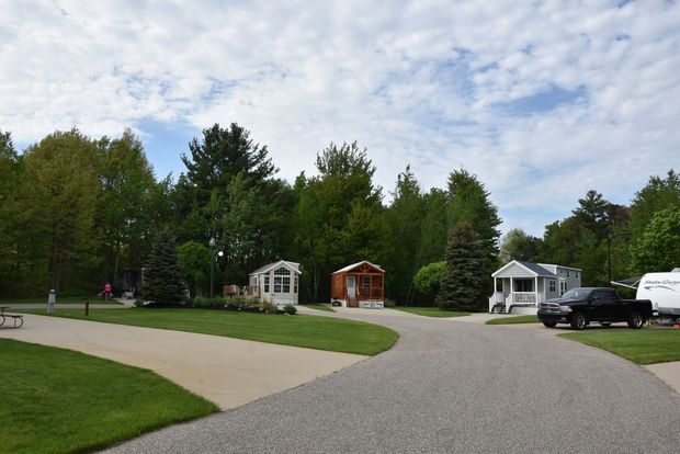 A park with a lot of houses and a truck parked on the side of the road.