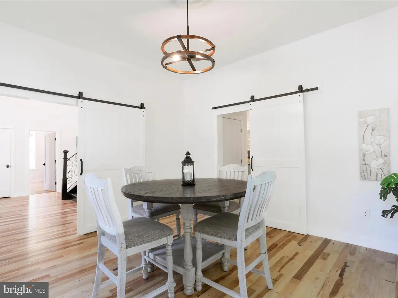 Dining area with a round table and chairs, sliding doors, and a decorative light fixture.