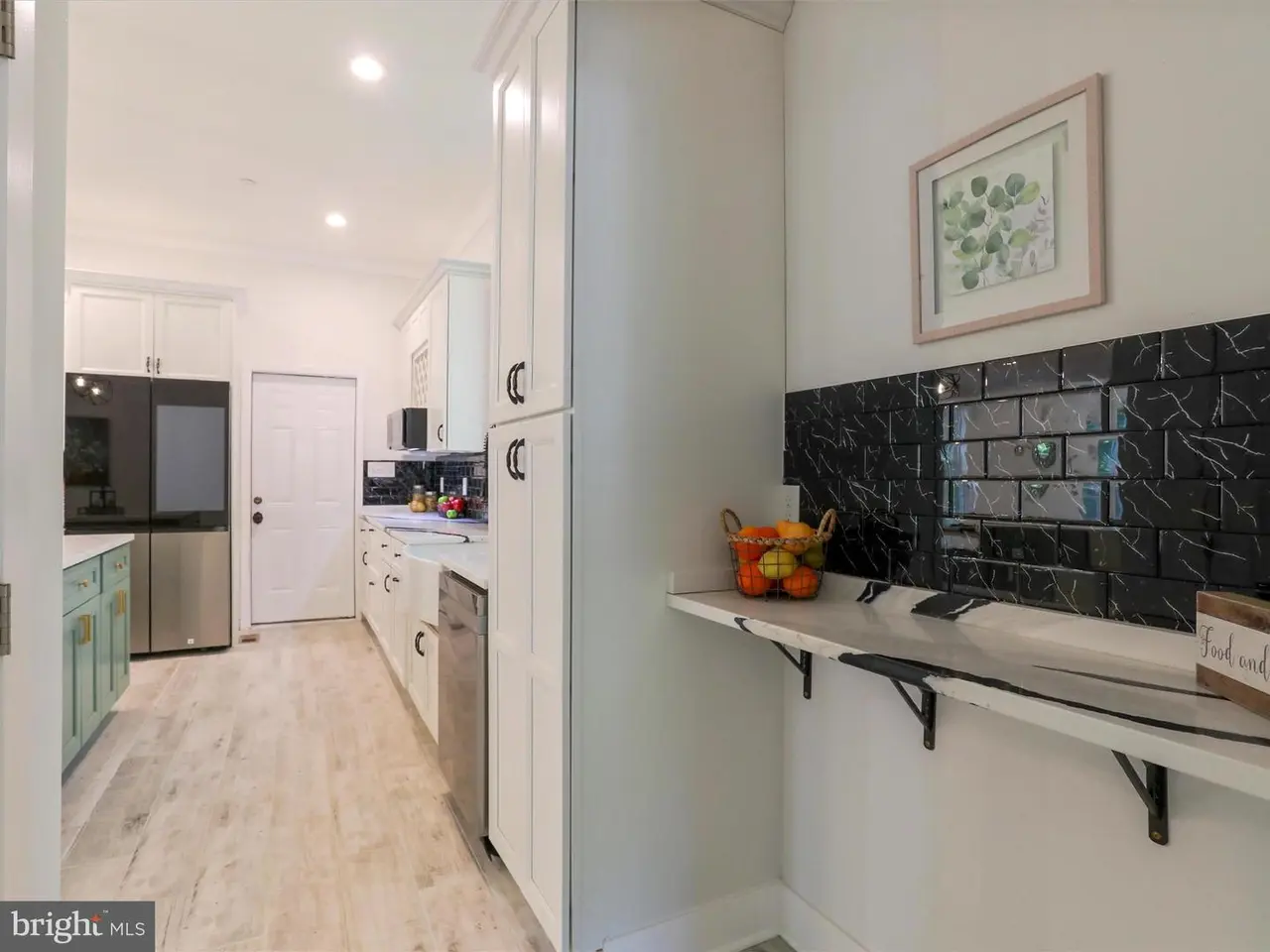 Kitchen with white cabinets, stainless steel appliances, and a tiled backsplash.