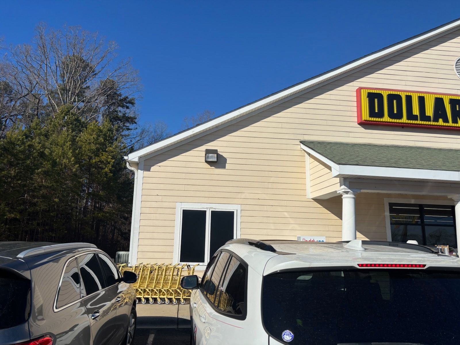 Dollar General storefront with parked cars in front on a sunny day