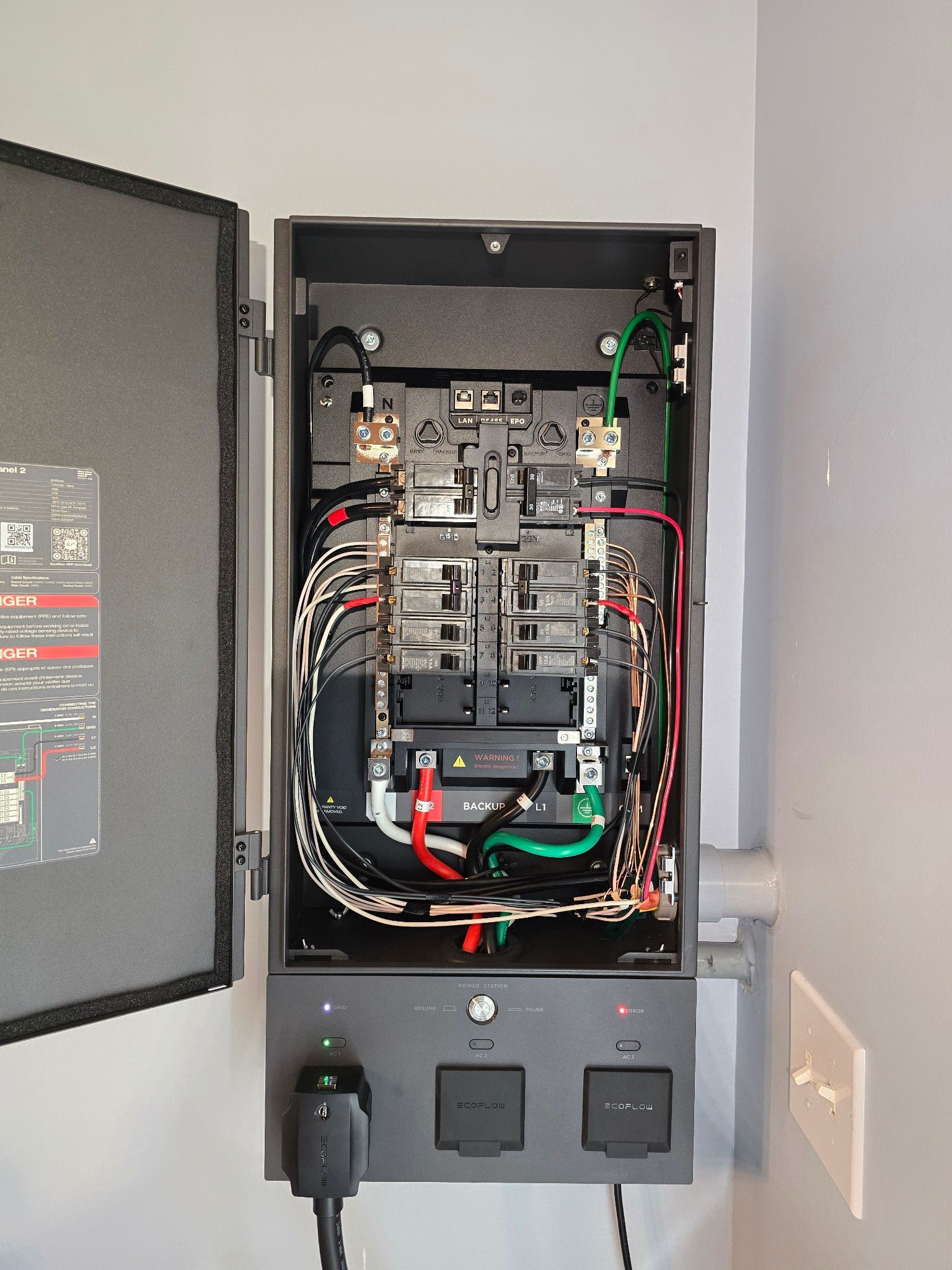 Open electrical breaker panel with wiring and switches inside a wall cabinet