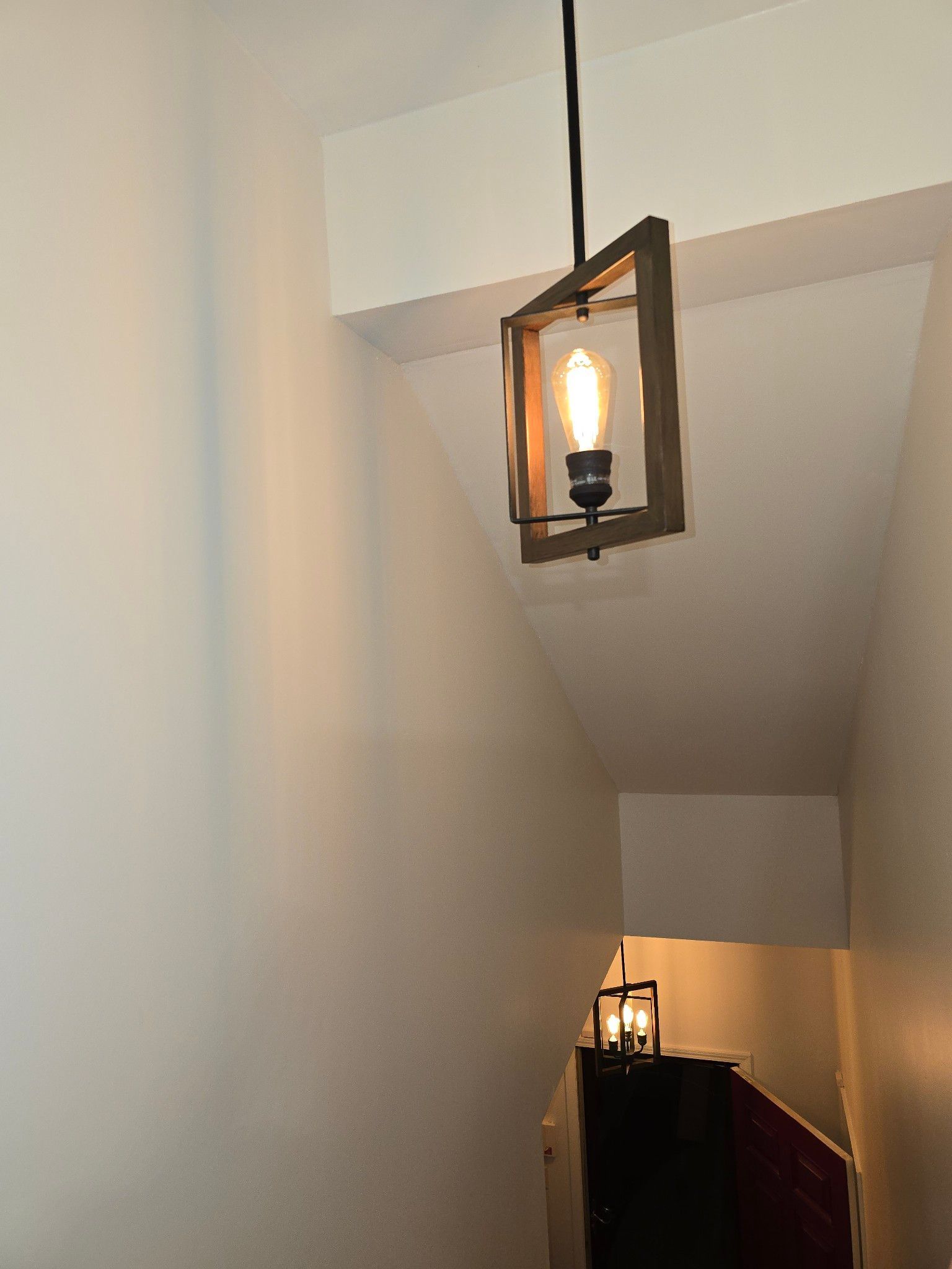 Hanging lantern on a staircase, with a second lantern visible below on the landing.