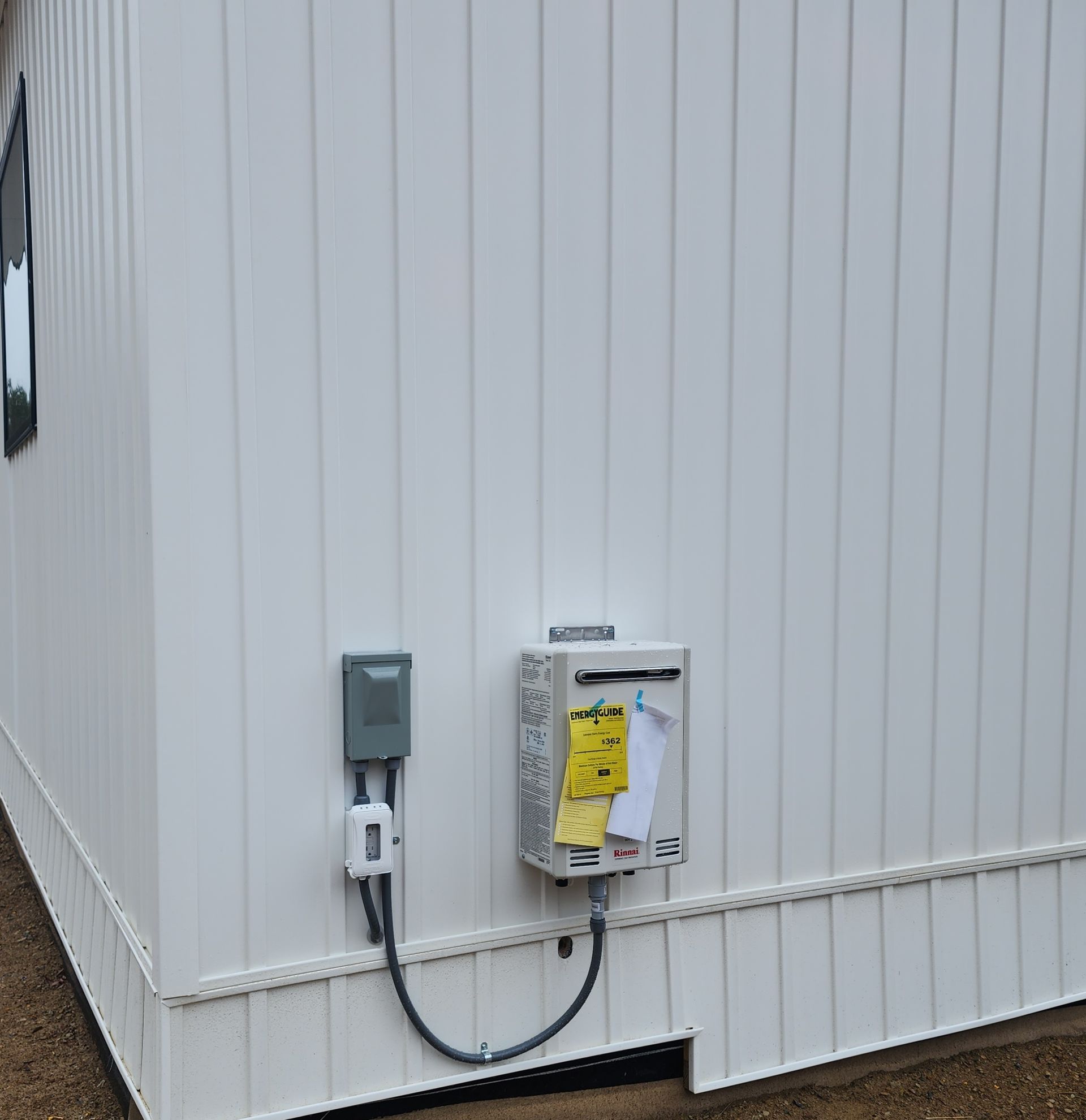 White building exterior with electrical meter and utility boxes mounted on the wall