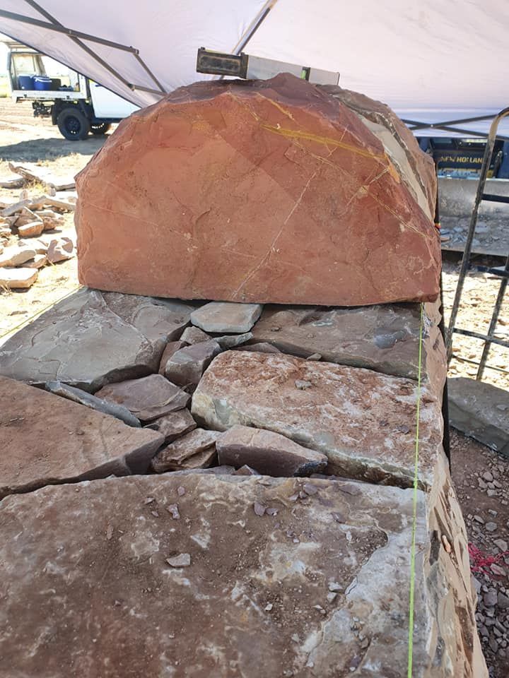 A Large, Rounded Red Sandstone Block Sits Atop a Dry-stone Wall — High End Stone Masons in West End, QLD