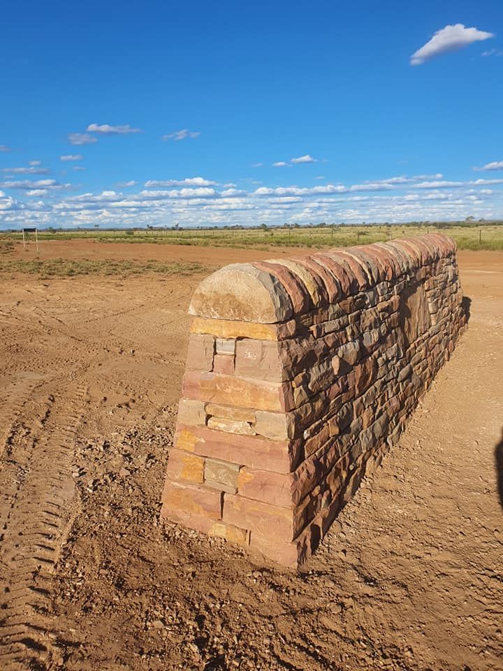 A Low, Wedge-shaped Stone Wall Stands in a Dry — High End Stone Masons in West End, QLD