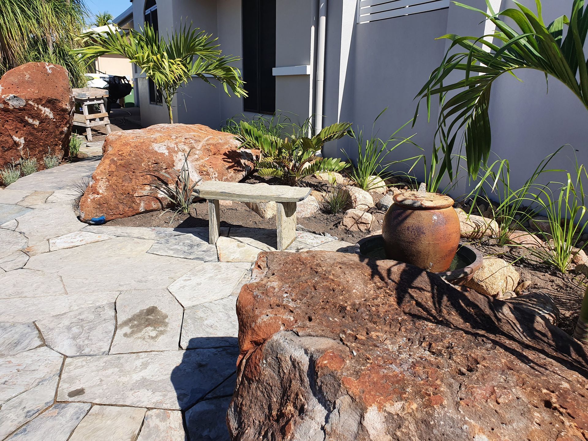 A Stone-paved Garden Path Leads Toward a Small Bench — High End Stone Masons in West End, QLD