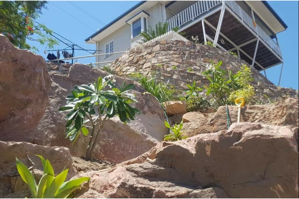 Stone steps climbing a lush, green hillside beside a rock wall— High End Stone Masons in West End, QLD