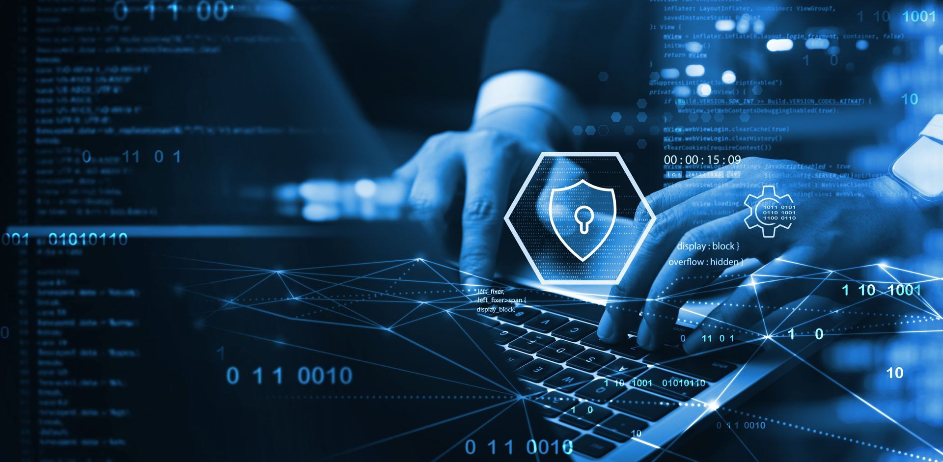 Person typing on laptop with cybersecurity shield and digital code overlay Person typing on laptop with cybersecurity shield and digital code overlay