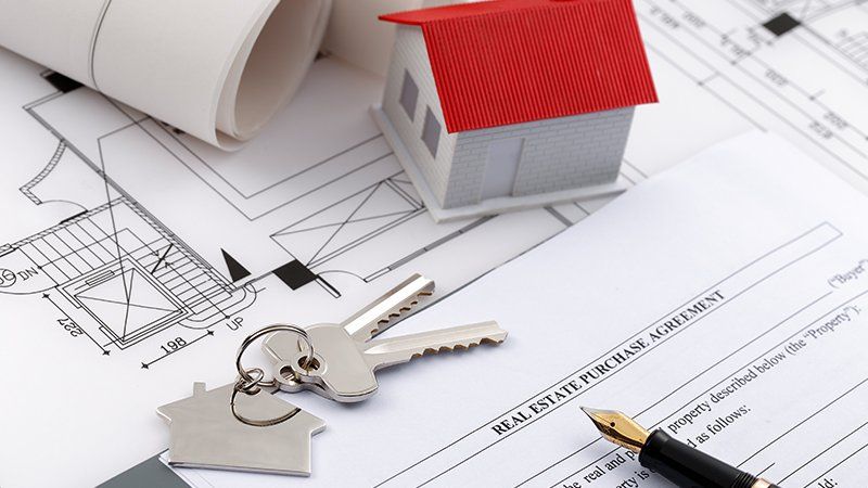 real estate purchase agreement with keys and a small red house - property law practice area image