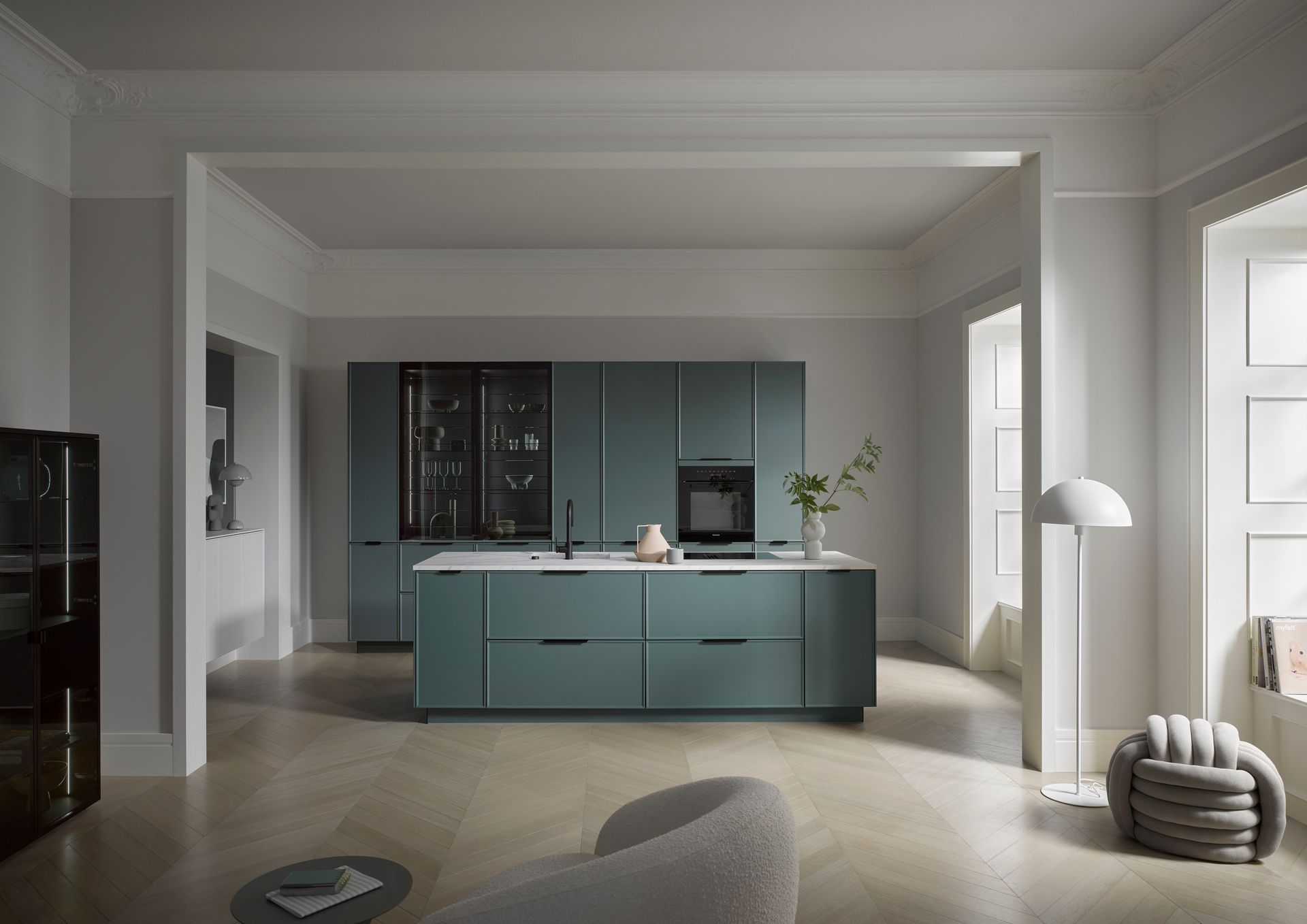 Moderne minimalistische Küche mit türkisfarbener Kochinsel in einem hellen, offenen Raum