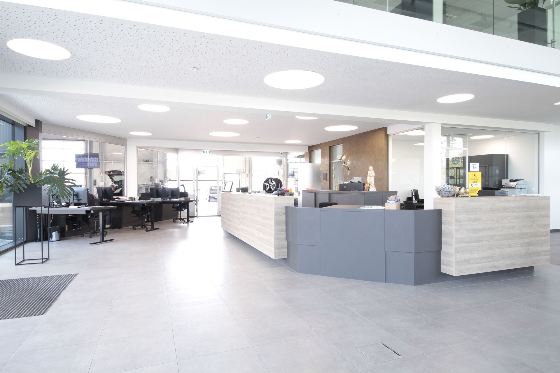 Helle, moderne Bürolobby mit Empfangstresen, Stühlen und großen Fenstern