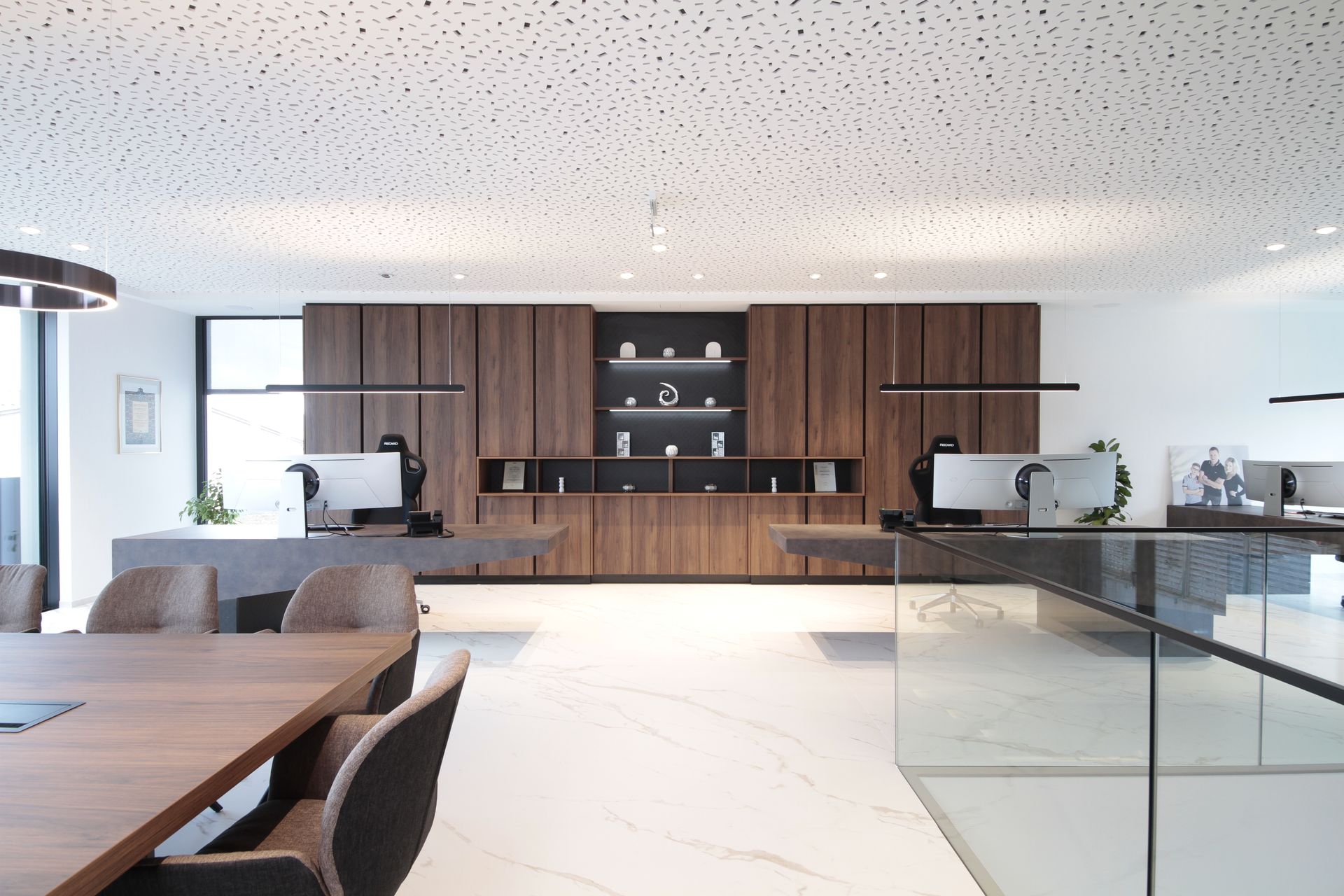 Moderne offene Küche mit Holzschränken, Marmorinsel und Glasgeländer in einem hellen, minimalistischen Haus