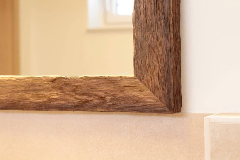 Nahaufnahme einer rustikalen Ecke eines Holzbilderrahmens an einer hellen Wand