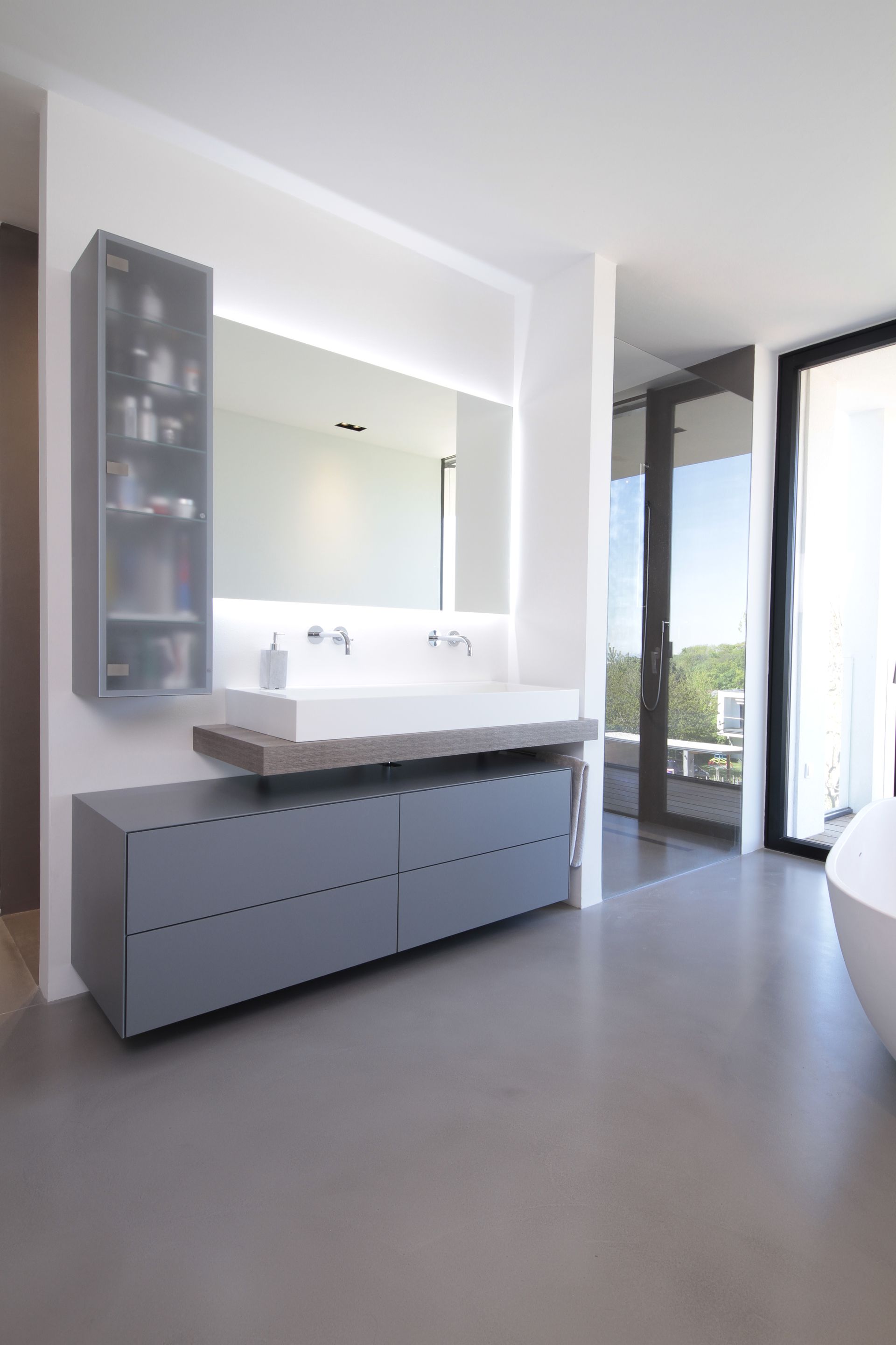 Modernes Badezimmer mit schwebendem Doppelwaschtisch, großem Spiegel und Duschtür aus Glas, beleuchtet von natürlichem Licht