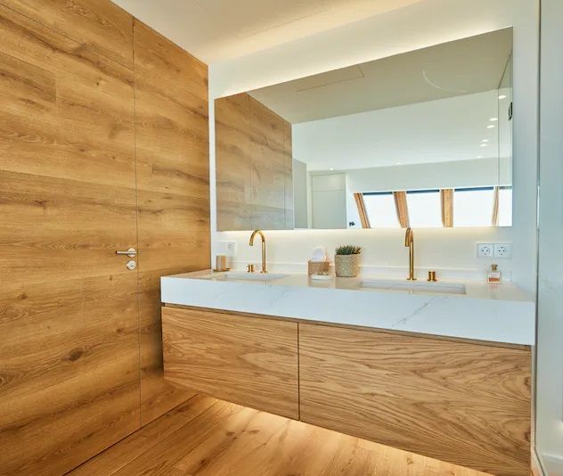 Modernes Badezimmer mit holzvertäfeltem Waschtisch, weißer Arbeitsplatte und großem Spiege