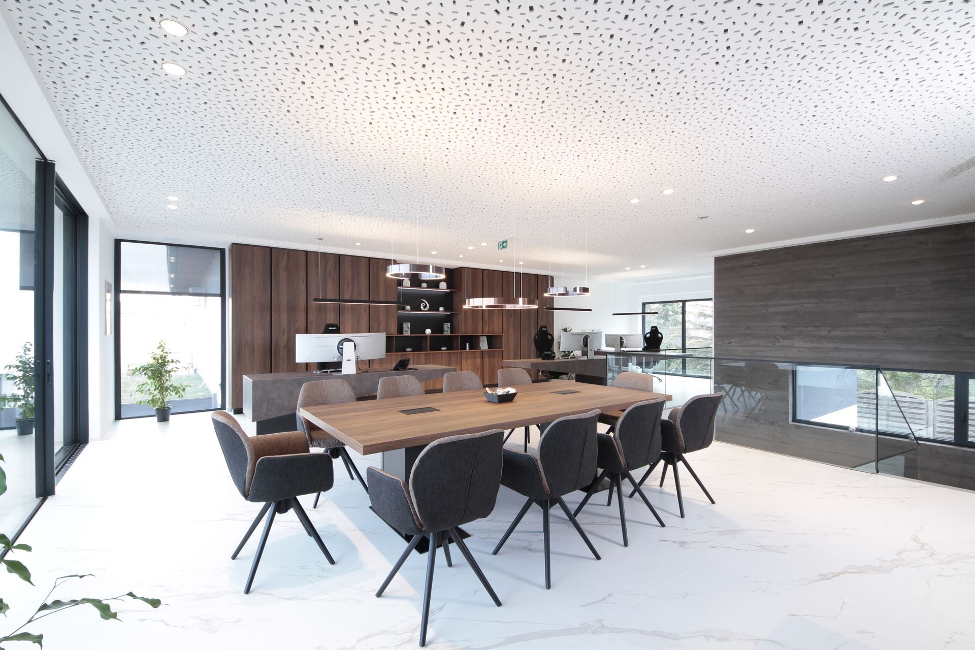 Modernes Esszimmer mit langem Holztisch, schwarzen Stühlen und einem eleganten, offenen Küchen-/Wohnbereich