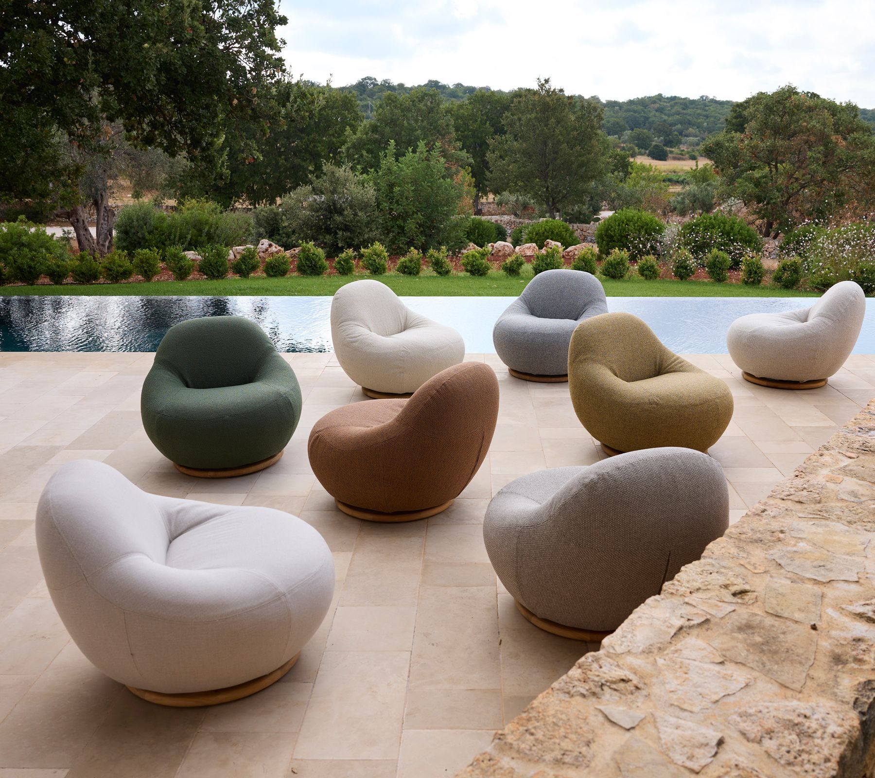 Terrasse mit farbenfrohen Sitzsäcken neben dem Pool und Gartenblick