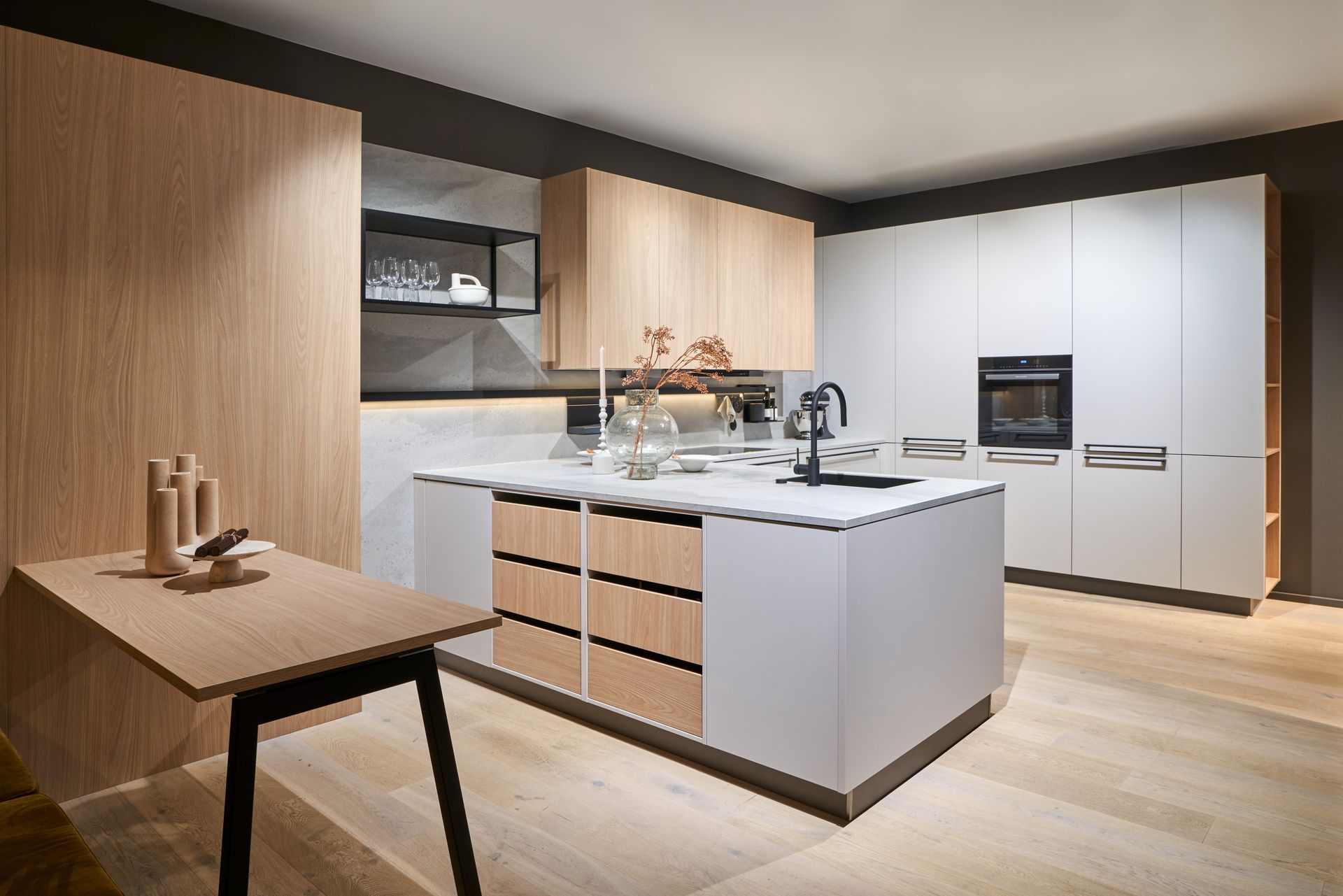 Moderne, minimalistische Küche mit weißer Kochinsel, Holzschränken und Einbaugeräten