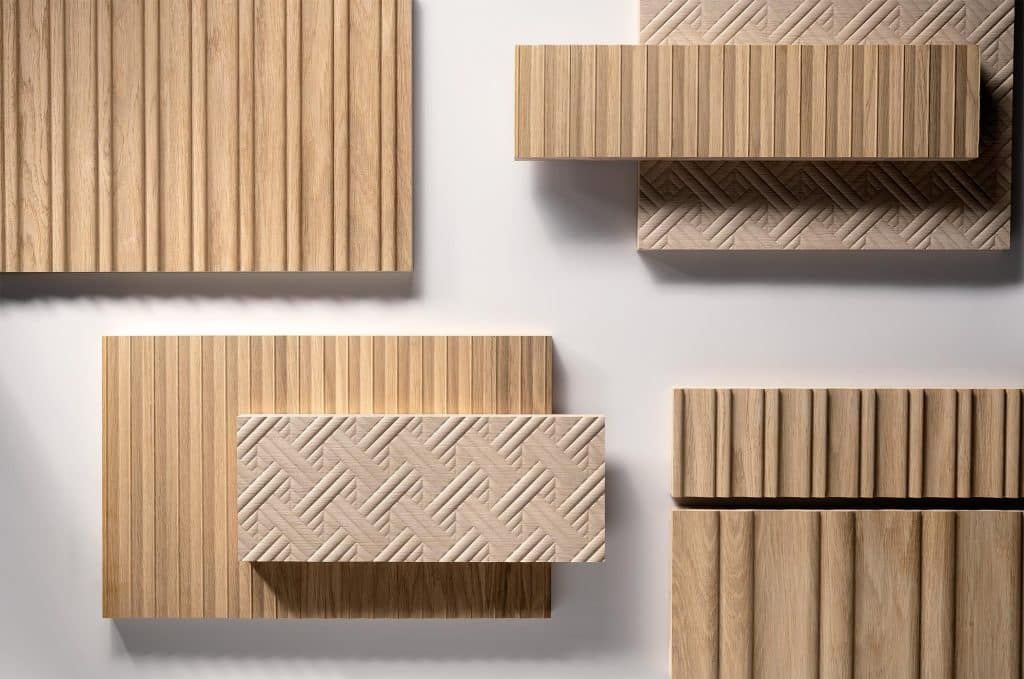 Rechteckige Holzblöcke mit Mustern sind in einem modernen geometrischen Layout auf hellem Hintergrund angeordnet.