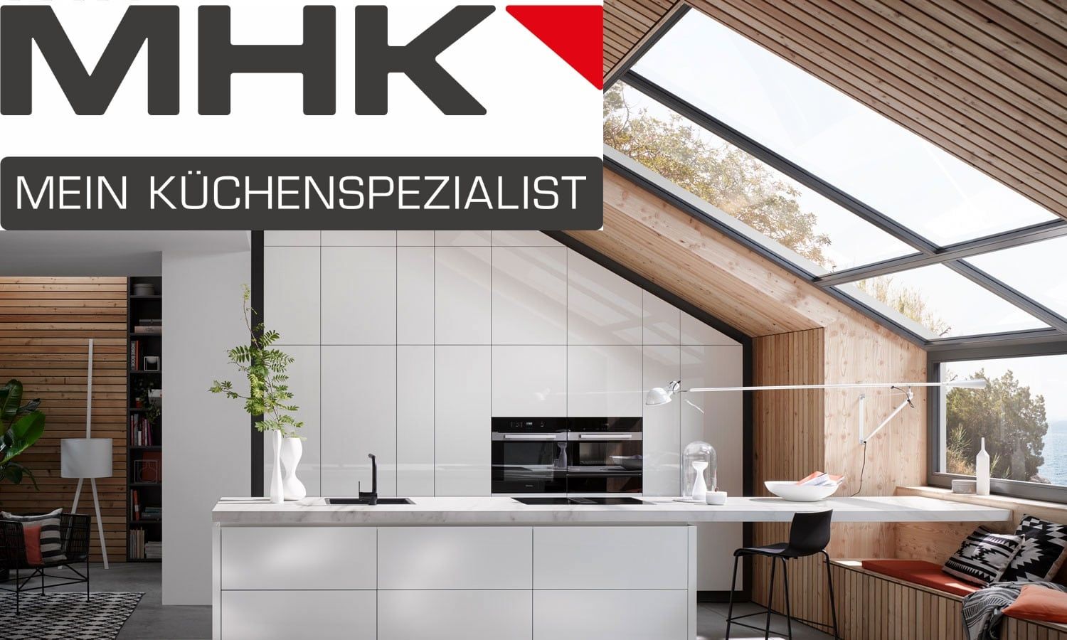 Das Logo des Küchenspezialisten MHK über einer modernen weißen Küche mit Oberlichtern und Holzelementen.
