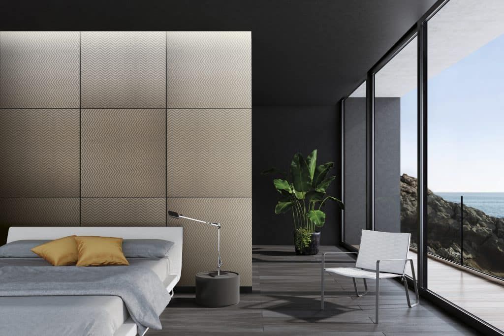 Modernes Schlafzimmer mit Bett, Stuhl, Pflanzen und bodentiefen Fenstern mit Blick auf die Landschaft