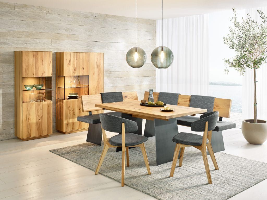 Modernes Esszimmer mit Holztisch, grauen Stühlen, Pendelleuchten und Einbauschränken.