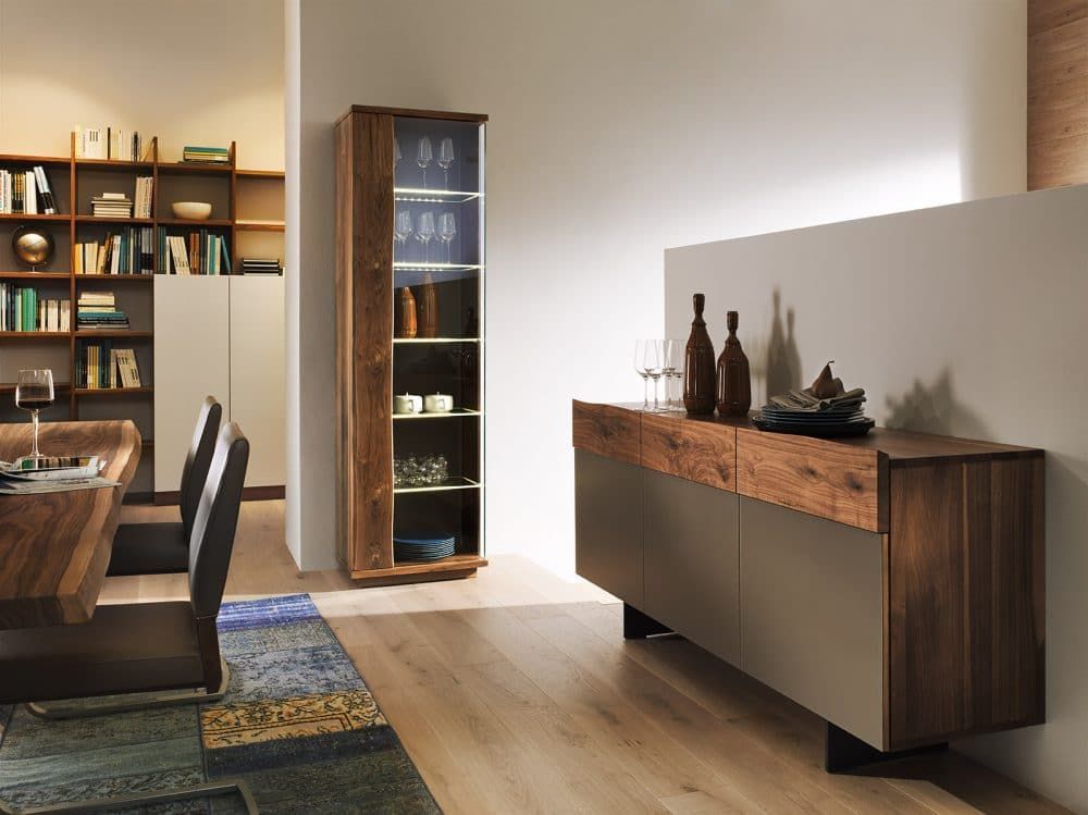 Modernes Esszimmer mit Holztisch, Regalen, Glasvitrine und Sideboard mit Flaschen