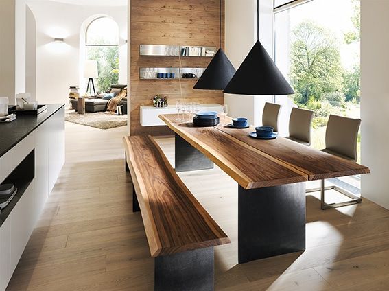 Modernes Esszimmer mit Holztisch, schwarzen Pendelleuchten und großen Fenstern mit Blick ins Grüne
