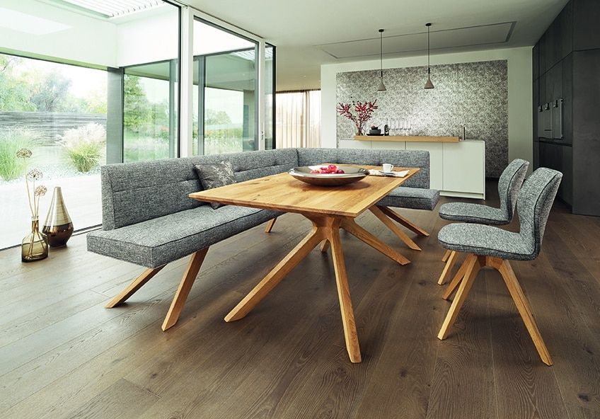 Modernes Esszimmer mit Holztisch, grauen Stühlen und großen Glastüren mit Blick ins Grüne