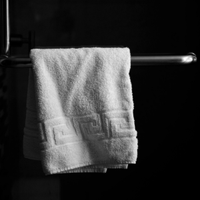 White towel hanging on a chrome bar against a dark background