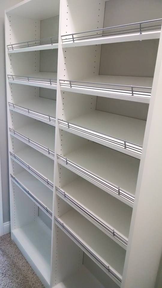 Empty white retail shelving with adjustable wire shelves in a store aisle