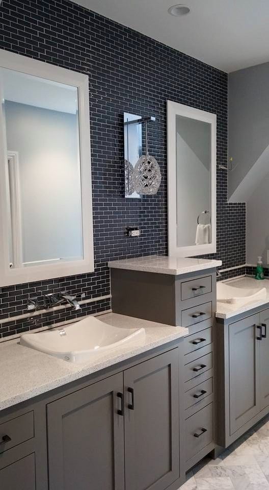 Modern bathroom vanity with double sinks, gray cabinets, and dark mosaic tile backsplash.