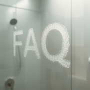 Frosted glass shower door with the letters “FAO” written in condensation