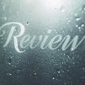 “Review” in white script on a misty glass surface with water droplets