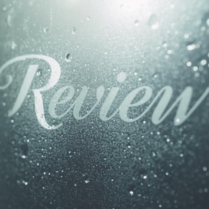 “Review” in white script on a misty glass surface with water droplets
