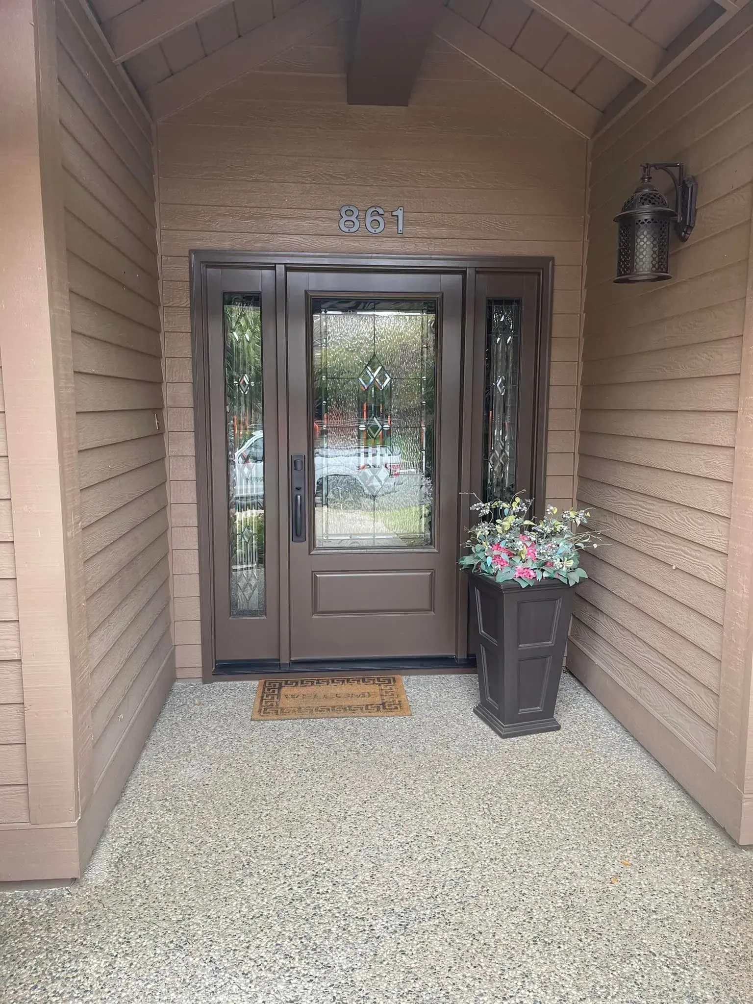 Brown front door with sidelights, address 