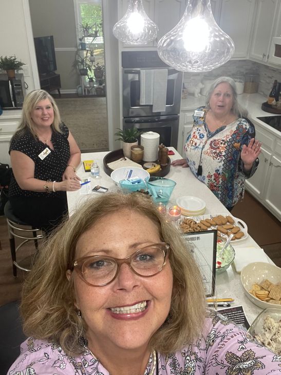 A Woman holding the camera taking a selfie at an Open House event.