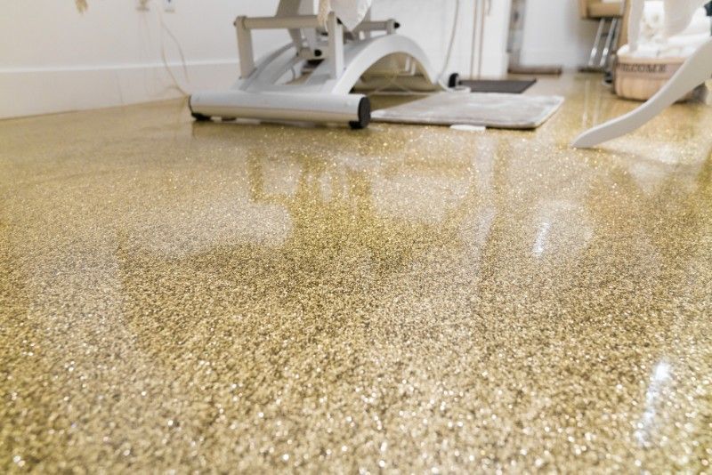 Shiny speckled gym floor with a workout machine in the background