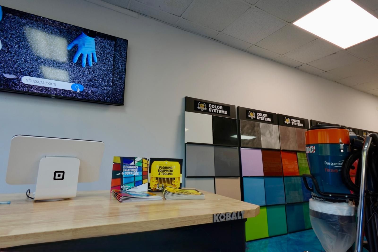 Computer counter with monitor, colorful phone cases, and a wall display in a retail store