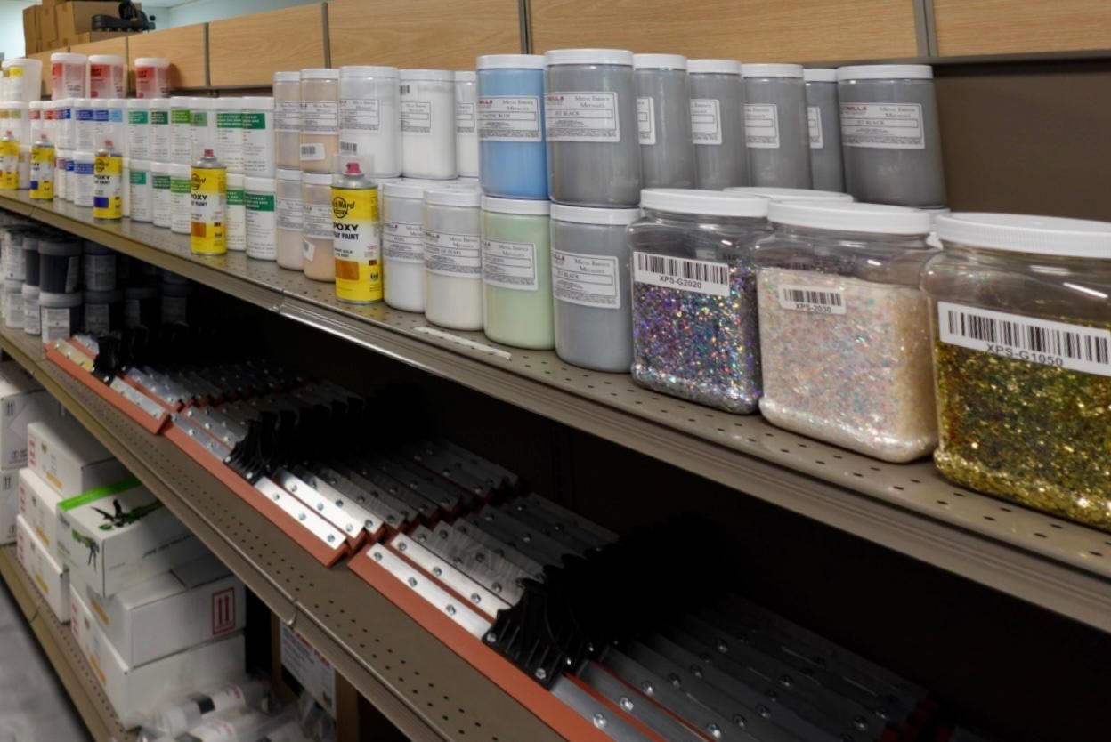 Store shelf with assorted jars and containers of paint and craft supplies