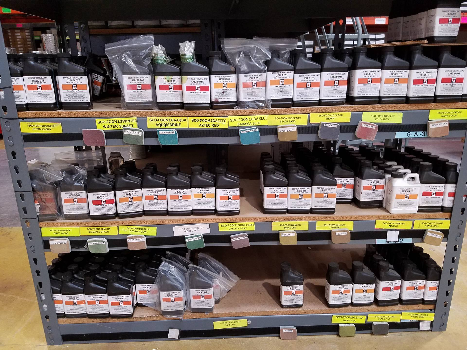 Shelves stocked with assorted hardware parts in clear plastic bins and labeled boxes in a store aisle