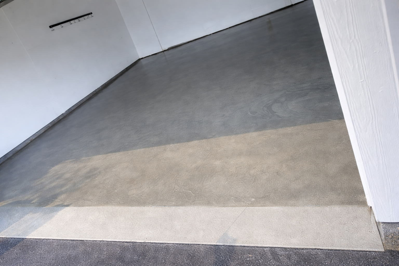 A concrete ramp slopes downward from a building. A white border is at the bottom.