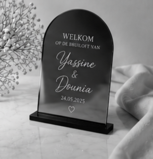 Zwart acryl welkomstbord voor de bruiloft van Yassine en Dounia met witte letters, gedateerd 24-05-2025.