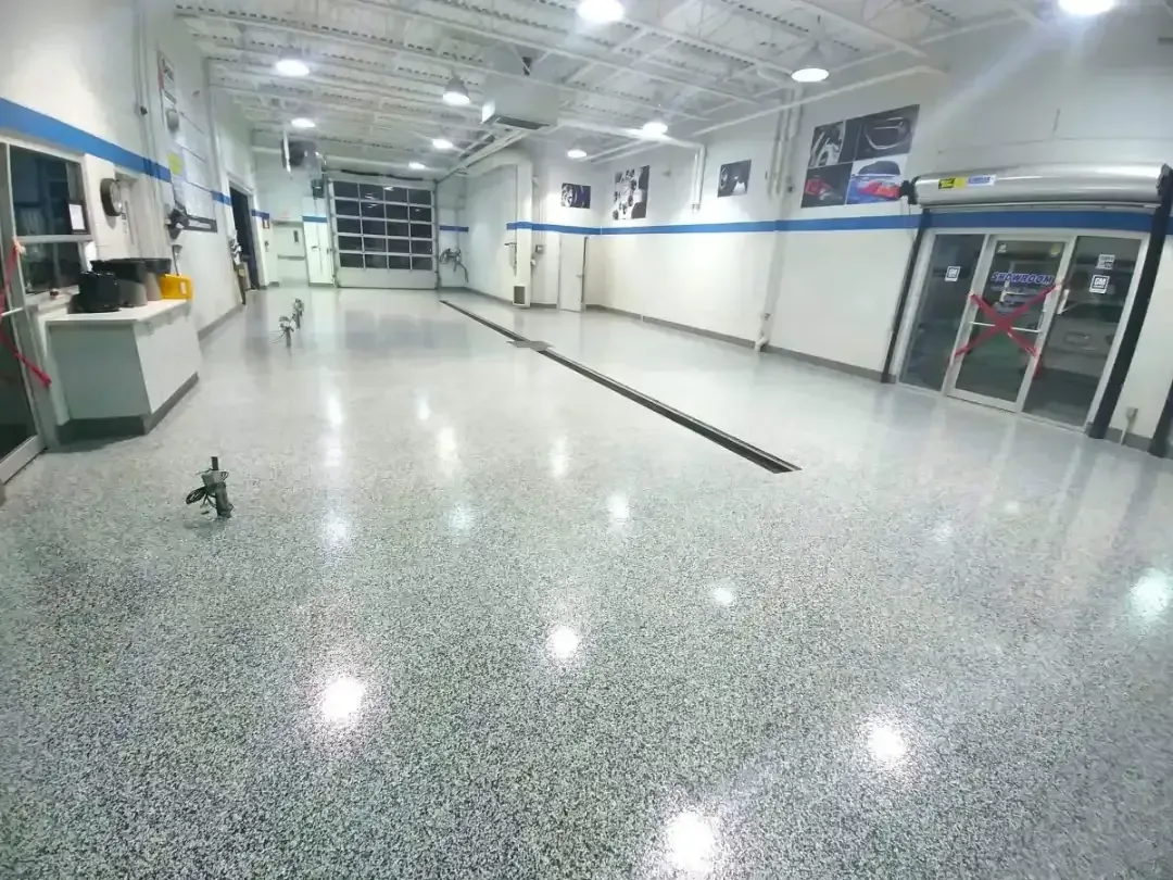 Empty indoor lobby with polished floor, white walls, and glass entrance doors.
