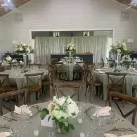 Elegant reception hall with round tables, floral centerpieces, and gray table settings