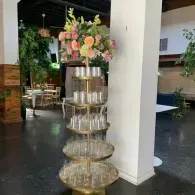 Decorative tiered stand with pink and peach flowers in an indoor patio